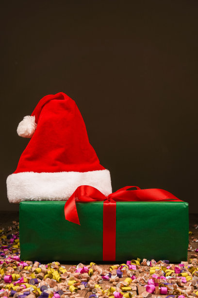 圣诞Flatlay礼盒和圣诞树装饰品的俯视图照片。木制背景上的圣诞老人帽子。圣诞背景与文字的地方。Copyspace。圣诞树玩具。图片下载