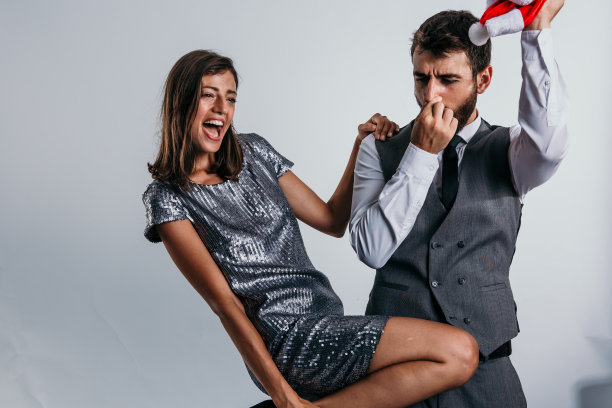 一个协调良好的商业二人组用温暖的拥抱和圣诞老人的帽子来庆祝新年的到来，工作室为他们的欢乐时刻提供了美丽的画布图片下载
