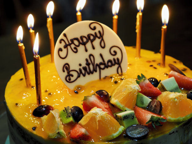 点燃生日蛋糕上燃烧的蜡烛图片下载