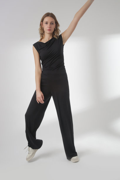 一系列的工作室照片，年轻的女模特穿着舒适的基本黑色服装，无袖衬衫和阔腿裤，舒适的家居服由有机棉制成图片下载