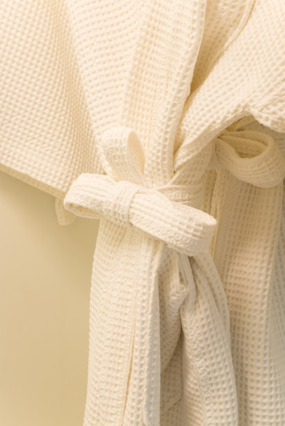 木制衣柜里的白色华夫格浴袍。图片下载