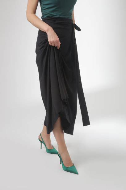 一系列的工作室照片的年轻女模特穿着简单美丽的服装，棉黑色及地裙和绿色无袖上衣图片下载