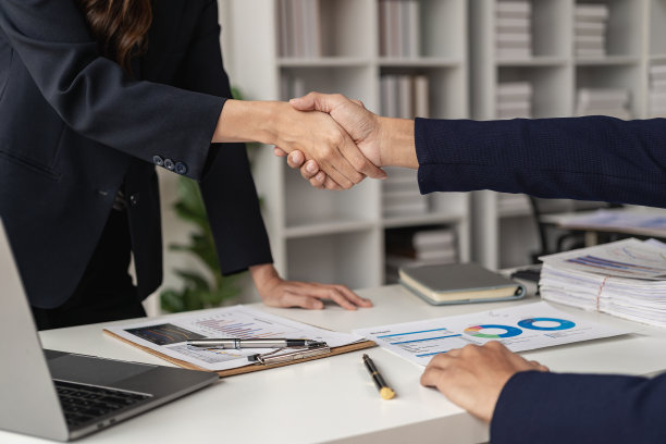 年轻的商人在成功交易后握手，一起工作，一起开始新的生意。特写照片。图片下载