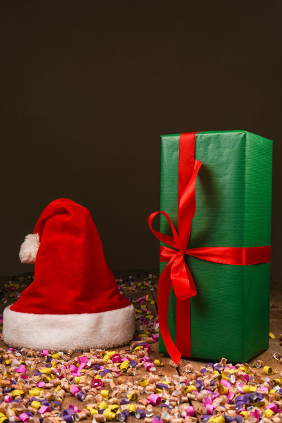 圣诞Flatlay礼盒和圣诞树装饰品的俯视图照片。木制背景上的圣诞老人帽子。圣诞背景与文字的地方。Copyspace。圣诞树玩具。图片下载