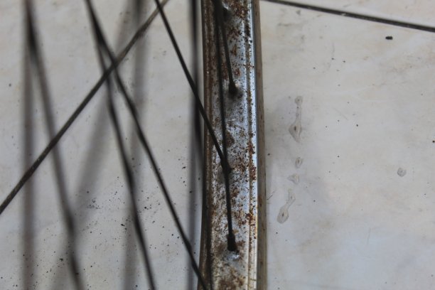 近距离生锈的铬彩色自行车车轮与生锈的辐条模糊的背景图片下载