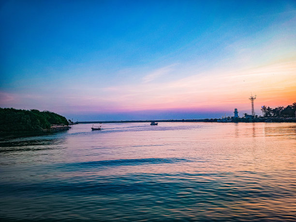 这张照片捕捉到了海滩和大海宁静的夜景，天空沐浴在温暖的橙色光线中。图片下载