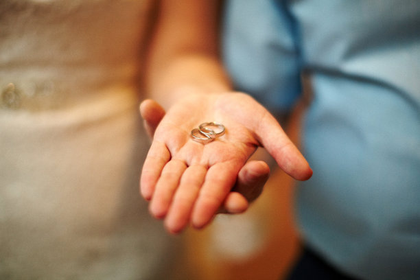 的婚礼。男人和女人的手在温暖柔和的阳光下黑暗的背景。新的家庭诞生了。高质量照片图片下载