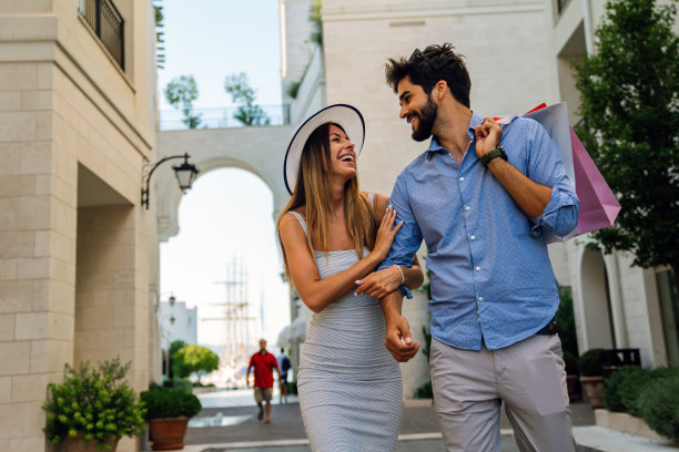兴奋的人们开心地购物。一对年轻夫妇享受暑假的户外照片图片下载