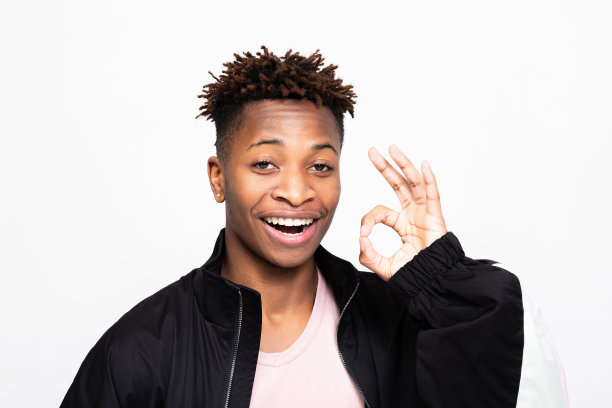 照片中的年轻、开朗、兴奋、积极、深肤色的非裔美国人在白色的背景上显示出“好”的标志图片下载