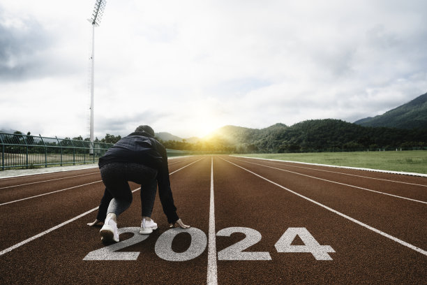 2024年新年快乐象征着新的一年的开始。准备在田径跑道上跑步的女子刻有2024年。开始挑战计划健康和商业成功的目标图片下载
