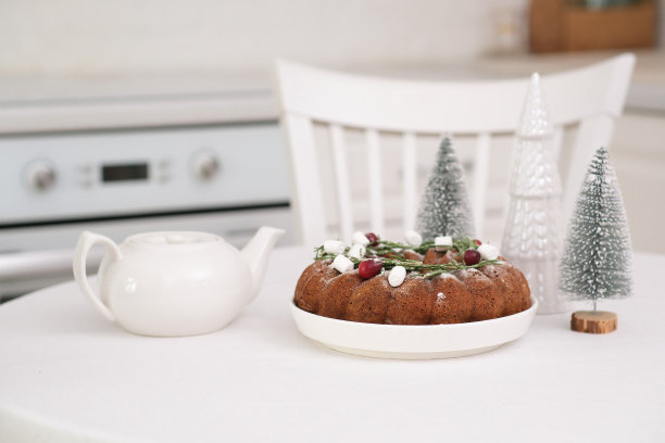圣诞家庭内部白色厨房圣诞巧克力束蛋糕与新鲜浆果和迷迭香。冬天的烘烤。圣诞树，茶壶。高质量照片图片下载
