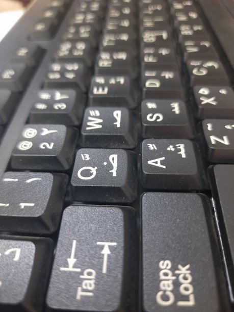 带有白色阿拉伯语和英语字母和数字的黑色电脑键盘图片下载