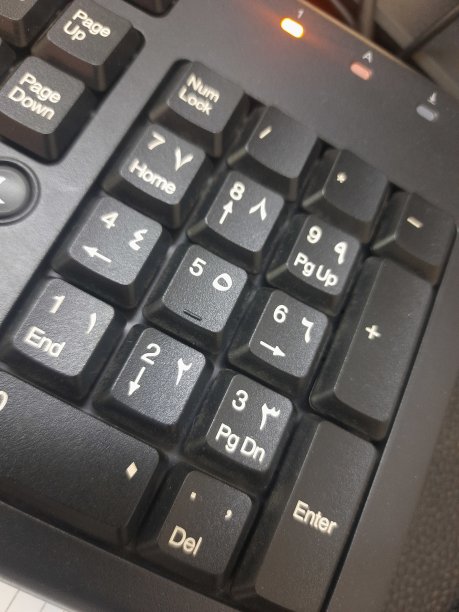 带有白色阿拉伯语和英语字母和数字的黑色电脑键盘图片下载