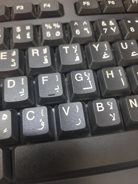 带有白色阿拉伯语和英语字母和数字的黑色电脑键盘图片下载