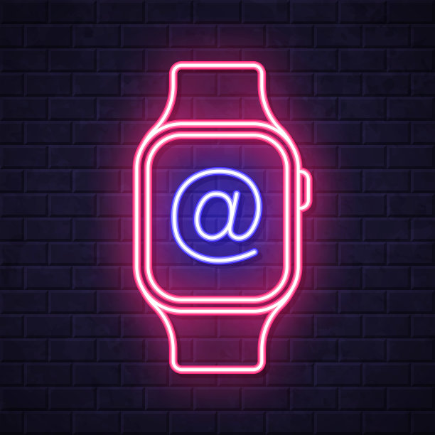 带有At符号的智能手表。在砖墙背景上发光的霓虹灯图标图片下载