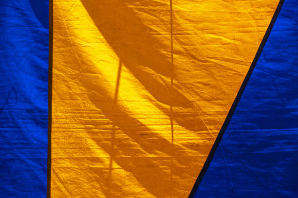 旧马戏帐篷色彩斑斓的质感，形成蓝黄几何图形。图片下载