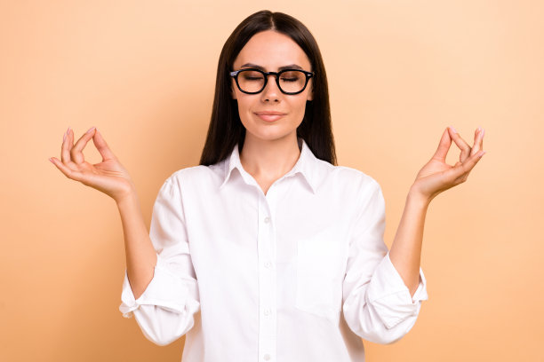 照片的梦幻积极的女士穿着白色衬衫眼镜闭着眼睛享受瑜伽孤立米色背景图片下载