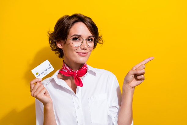 美丽的年轻女子模特白衬衫手帕选择万事达卡支付手指直接模拟孤立的黄色背景图片下载