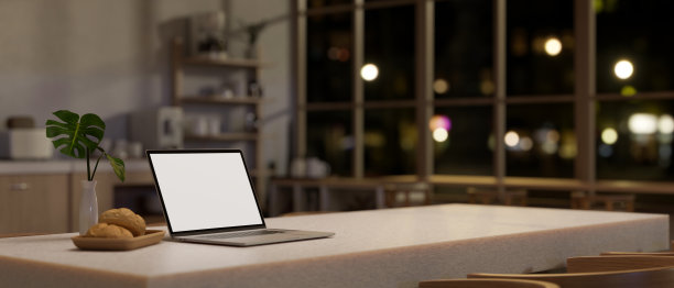 夜晚，斯堪的纳维亚厨房里现代白色餐桌上的白屏笔记本电脑模型。图片下载