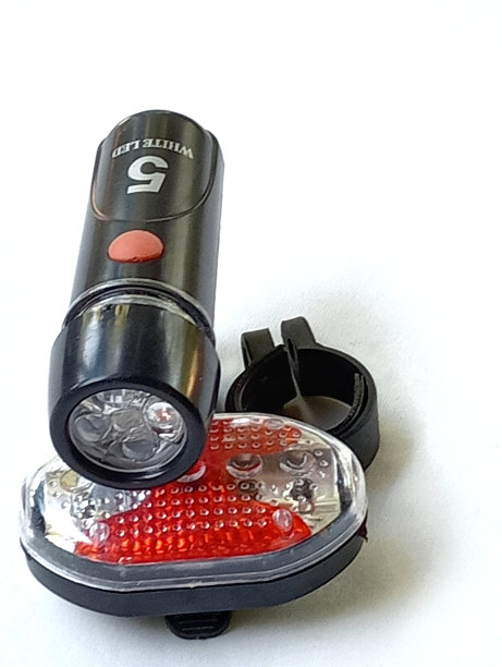 黑色自行车前灯和尾灯，使用电池放置在一个白色的背景。图片下载