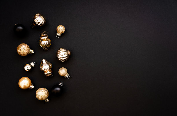 金色和黑色的圣诞球装饰在黑色的背景上图片下载