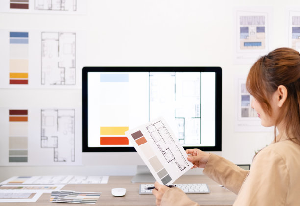 年轻的亚洲女性室内设计师或建筑师，在办公室用图纸，材料样品和电脑进行创意项目。经营房地产，家装装修理念。图片下载