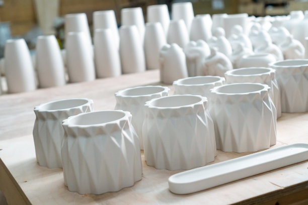 石膏成品:花瓶、小雕像、碗。在车间用石膏制作、铸造家居装饰用的碗碟、花瓶。在工艺品和家居装饰行业成功的微型企业。图片下载