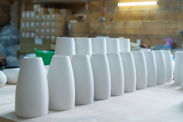 石膏成品:花瓶、小雕像、碗。在车间用石膏制作、铸造家居装饰用的碗碟、花瓶。在工艺品和家居装饰行业成功的微型企业。图片下载