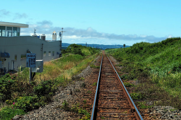 日本农村铁路的图片。铁路一望无际。背景是群山和蓝天。图片下载