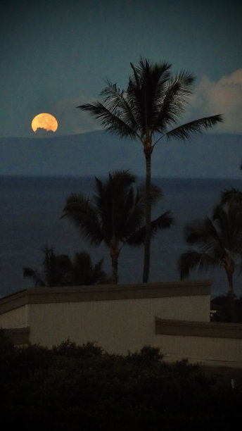 从夏威夷毛伊岛看，十月的一轮橙色满月开始落在lāna夏威夷岛上。图片下载