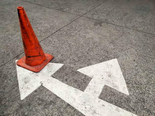 混凝土地板上的交通锥，照片的特写。图片下载