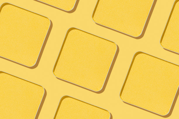 极简图案眼影黄色色板带阴影，单色照片背景，填充紧凑的眼影，闪亮的彩妆粉，方形金属包，化妆质感图片下载