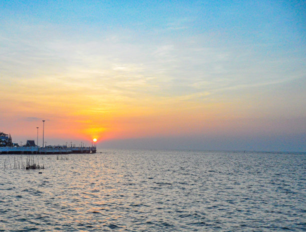 这些照片捕捉到了夜晚大海的宁静之美，橙色的天空在上面画了一幅令人惊叹的画布。图片下载