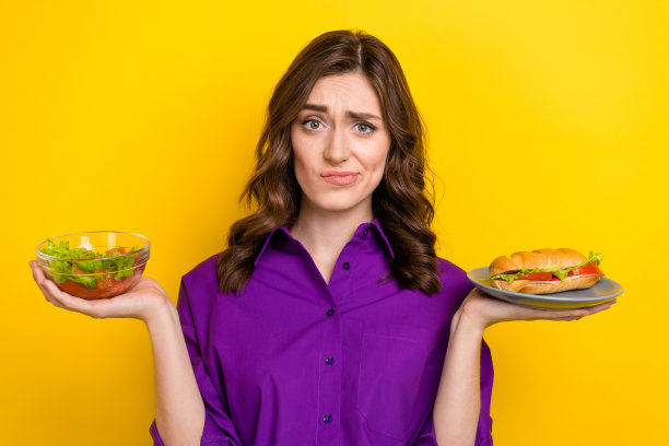 照片怀疑女士手捧碗新鲜沙拉盘三明治困境孤立在黄色背景图片下载
