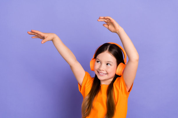 放松的年轻女孩，学校的孩子，照片的人享受听音乐，无线耳机，双手冰冷孤立在紫色的背景图片下载