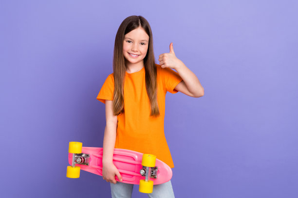 可爱的女儿的照片，女学生的孩子喜欢率积极享受骑滑板便士娱乐孤立的紫色背景图片下载