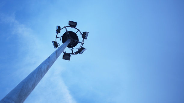 米高桅杆照明，泛光灯，杆在蓝色的天空图片下载