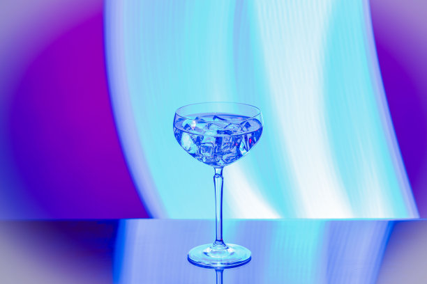 美丽的看法酒精饮料与冰块在丁香背景的水晶玻璃。图片下载