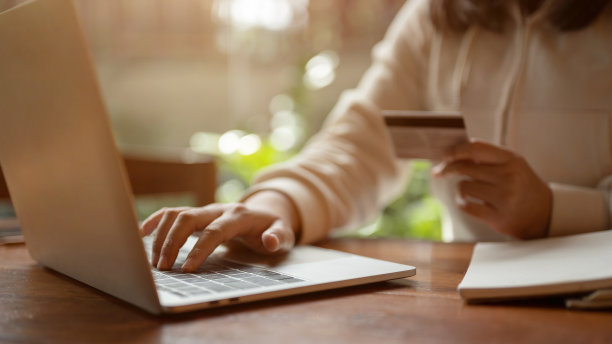 一名女子通过笔记本电脑在购物网站上注册她的银行帐户的局部照片图片下载