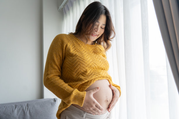 怀孕的亚洲妇女双手放在肚子上抚摸她的孩子，关心她的健康美丽快乐怀孕womanÂ温柔的心情怀孕照片图片下载
