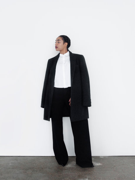 自信的年轻非洲裔美国混血儿女人看起来华丽的黑色长运动上衣裤子白衬衫时尚模特工作室肖像白光背景女孩与时尚的化妆迷人和有吸引力的商业女企业家图片下载