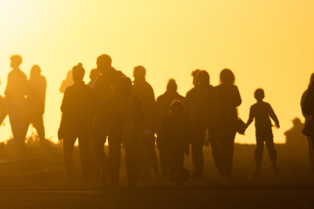 一群人的剪影向着黄灿灿的夕阳走去图片下载