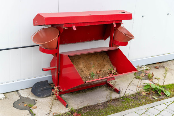 一个街道防火盾，上面有用来灭火的沙子，一把铲子和几个水桶。图片下载