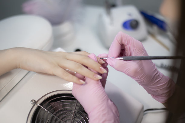 美甲师用指甲油涂指甲，近距离图片下载