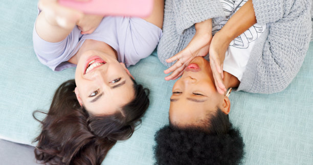 快乐，女性及以上在社交媒体上与朋友在床上自拍，个人资料照片或与有影响力的人在博客上发布。肖像，微笑和女孩一起在家里或卧室用有趣的表情符号或脸图片下载