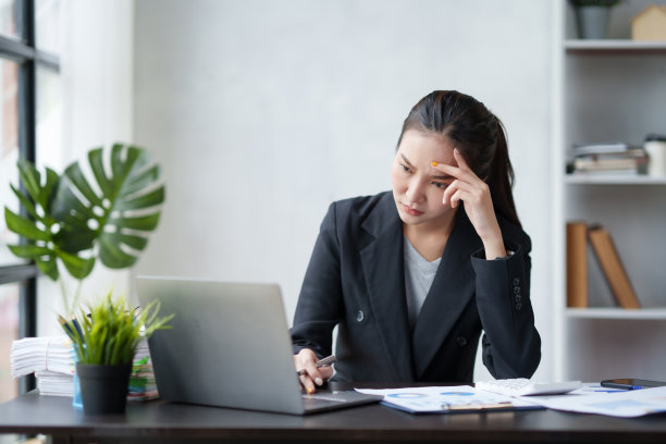 美丽的亚洲女商人厌倦了办公室的工作。因为在办公室用笔记本电脑工作时，眼睛看得太多了。图片下载