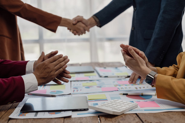 谈判成功后，两位商人正在洽谈生意，并在握手。握手是一种问候或表示祝贺的方式。特写照片图片下载