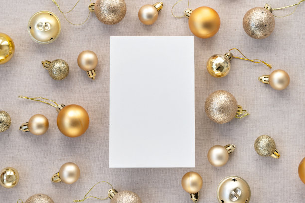空白纸卡模型，金色粉彩圣诞树装饰球，中性米色亚麻背景上的装饰品图案。审美节日商业品牌，社交媒体博客模板图片下载