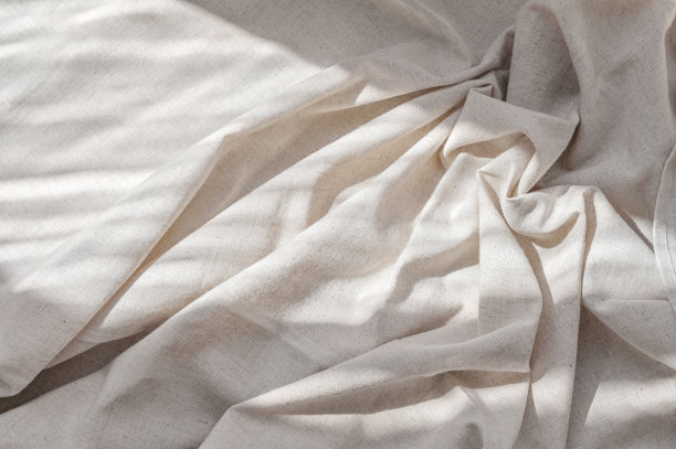 褶皱中性米色亚麻面料纹理与褶皱自然生活方式的阳光阴影，审美婚礼波希米亚背景，商业品牌模板图片下载