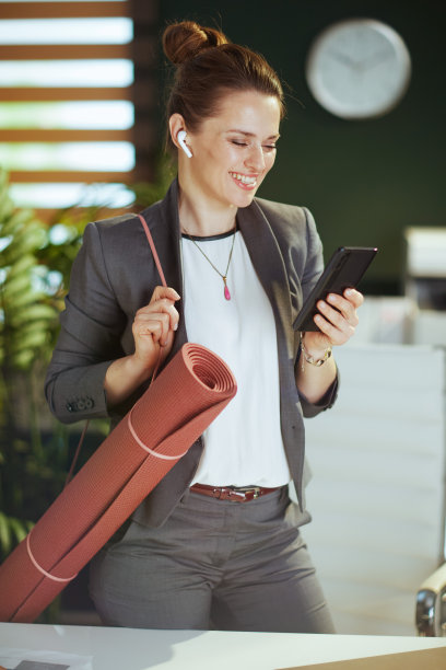 现代绿色办公室里微笑的现代商务女性图片下载